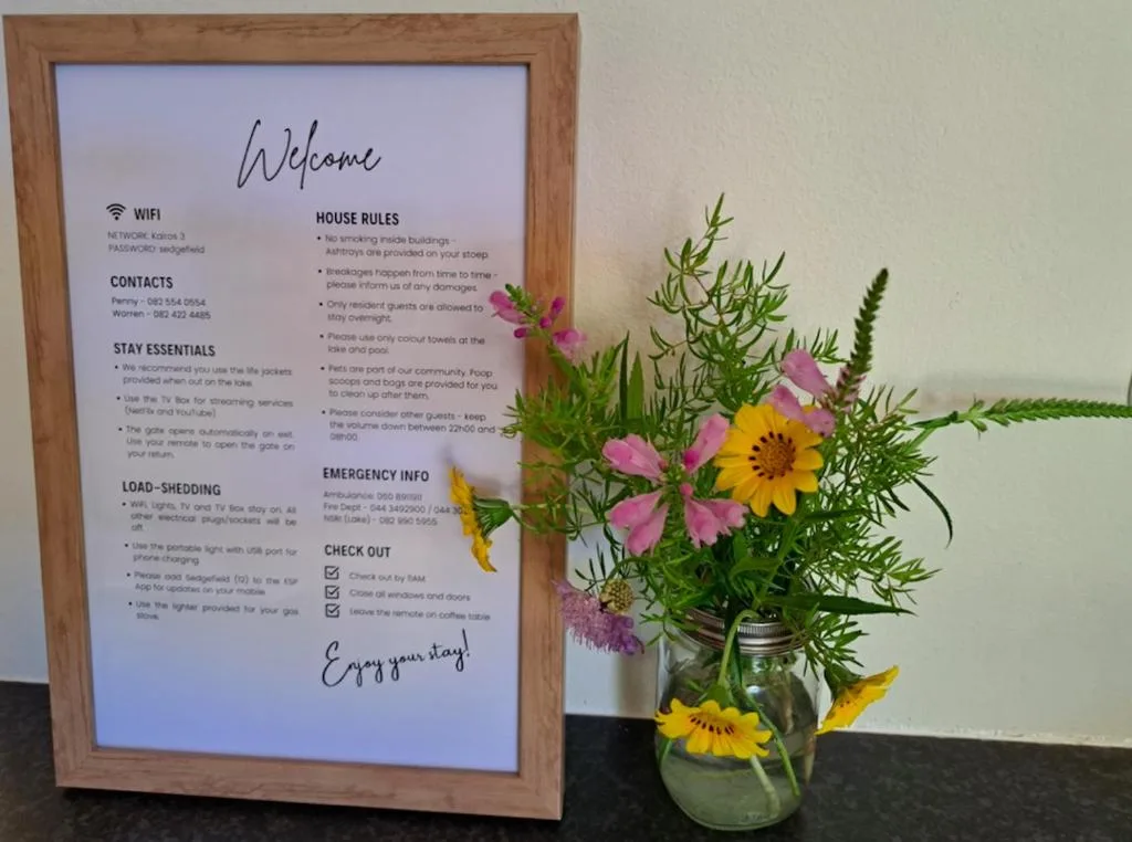 Welcome sign with house rules and fresh flowers in glass jar