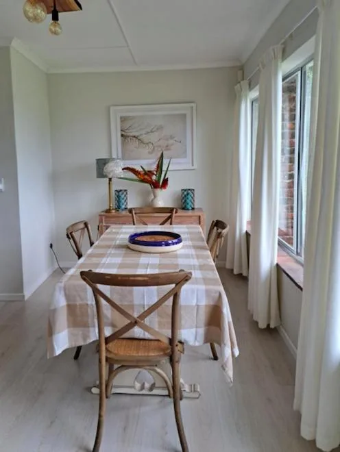 Bright dining room with checkered tablecloth and wooden chairs
