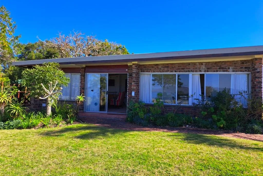 Modern brick holiday home with expansive windows and manicured garden lawn