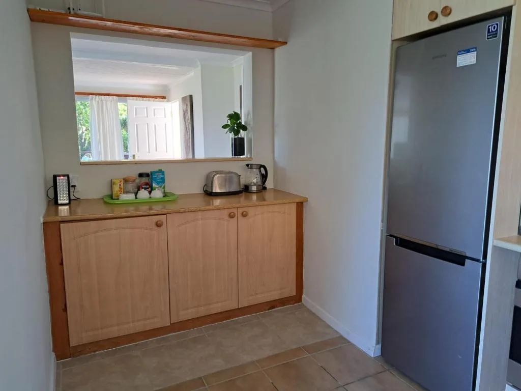 Kitchen area with wooden cabinets, refrigerator, and countertop appliances