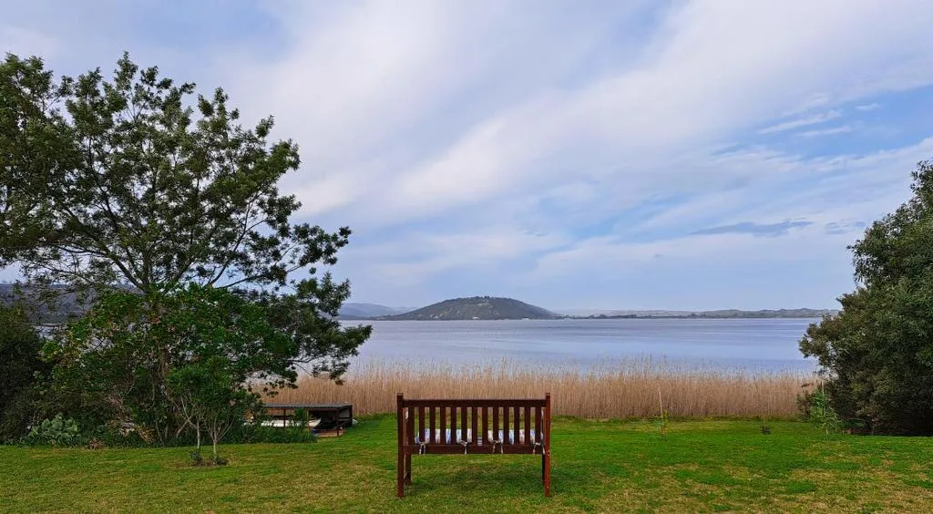 Scenic lagoon view with mountain and reeds from grassy garden area