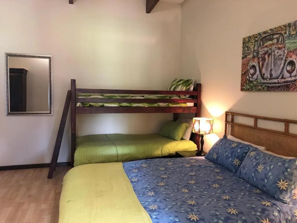 Bedroom with double bed, bunk bed, and warm lighting fixtures