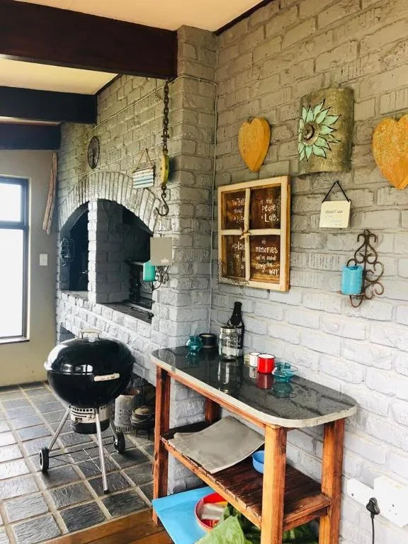 Outdoor braai area with pizza oven and stone fireplace feature wall