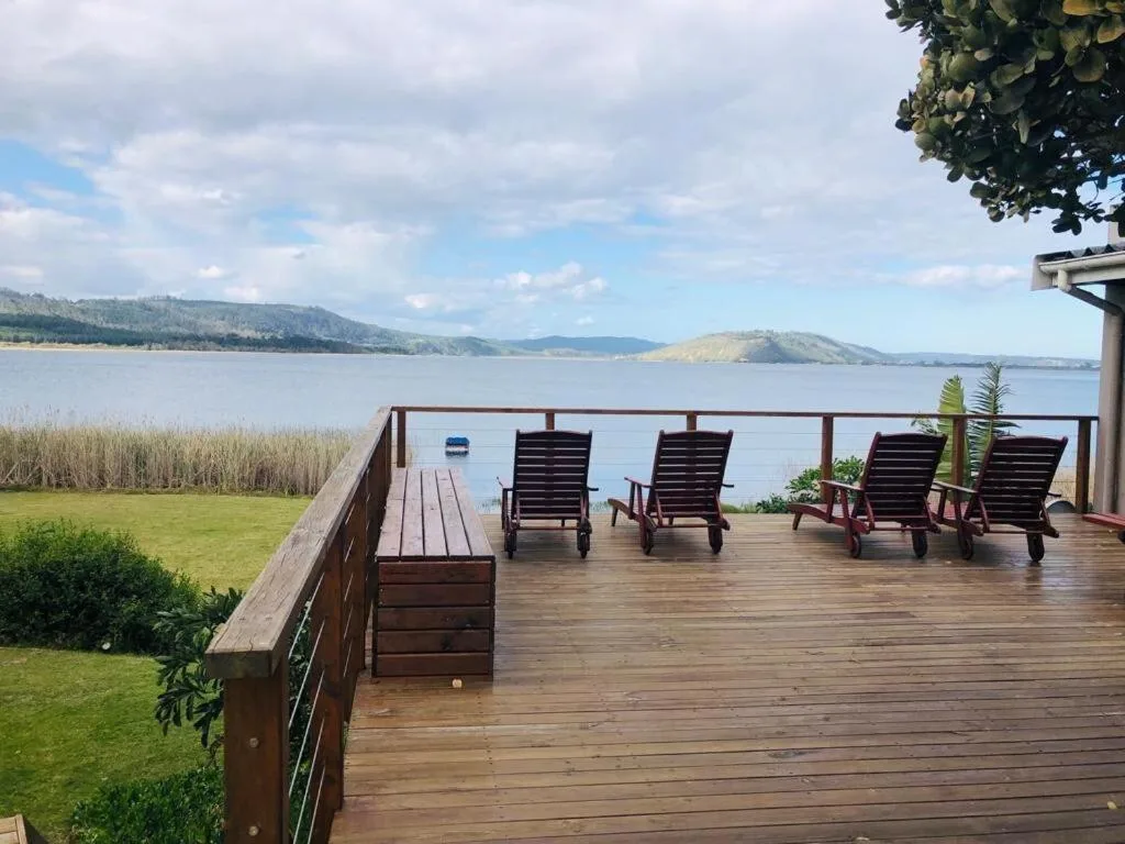 Wooden deck with lounge chairs overlooking Swartvlei Lake and mountains