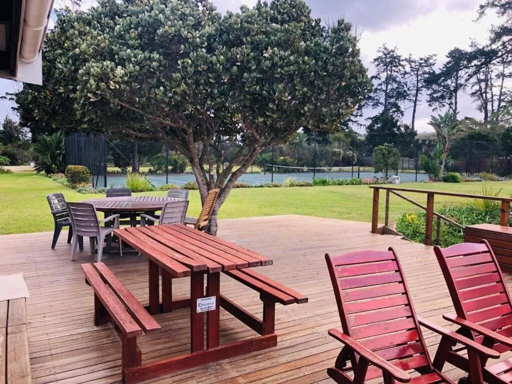Wooden deck with picnic tables and loungers overlooking manicured lawn