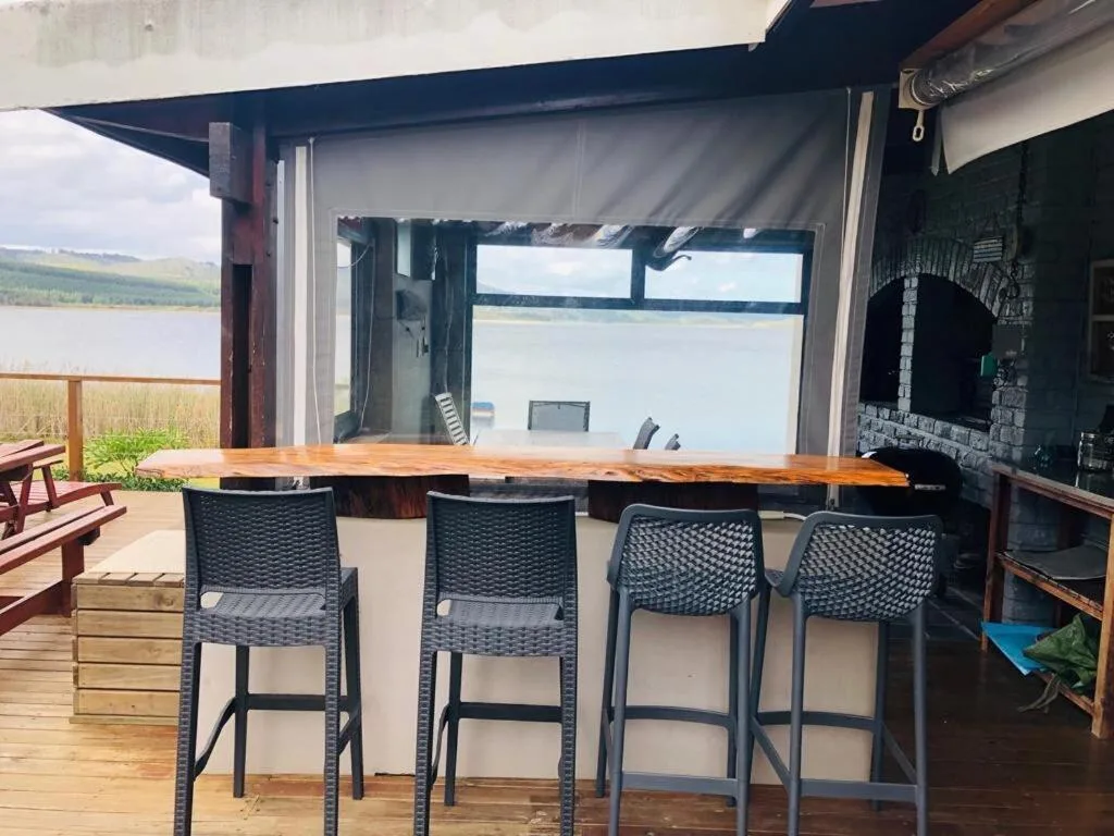 Outdoor bar counter with four bar stools overlooking the lake