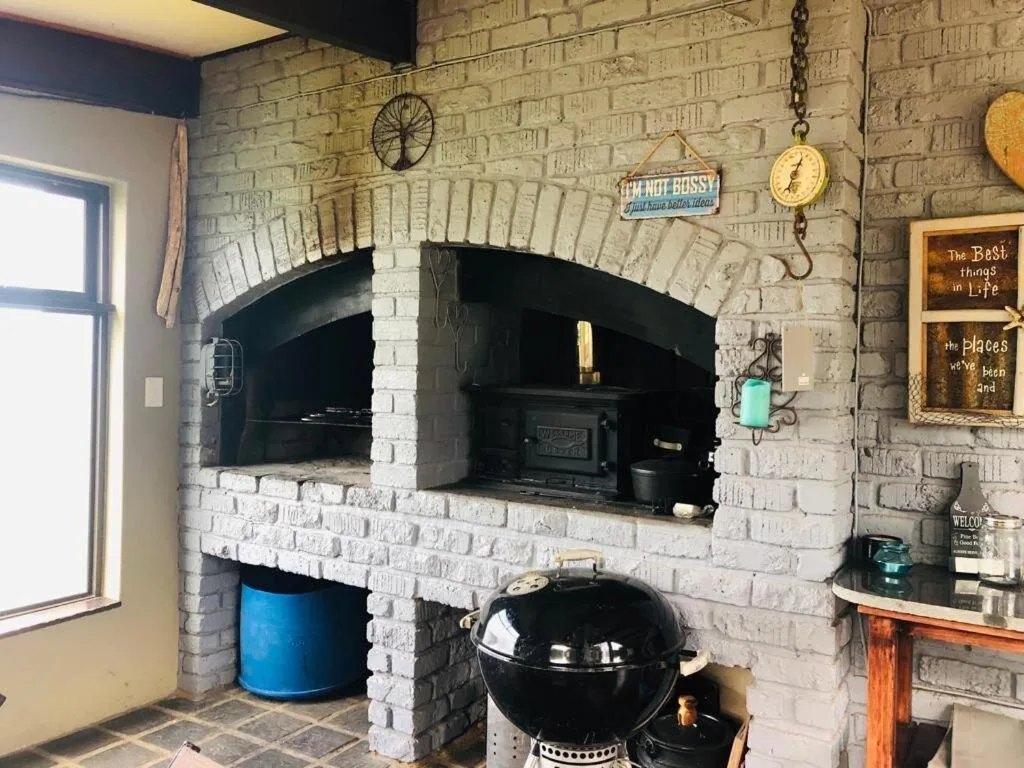 Brick fireplace with black wood stove and decorative braai area signs
