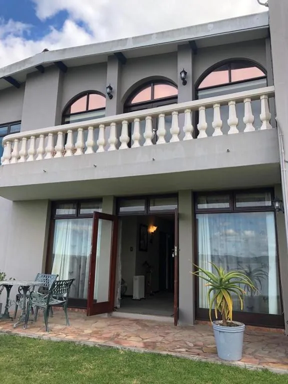 Modern two-story house with white balustrade balcony and arched windows