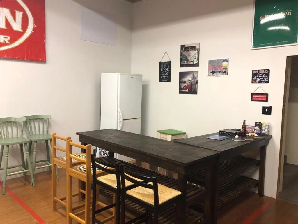 Kitchen with white refrigerator, dark dining table, and vintage wall decor