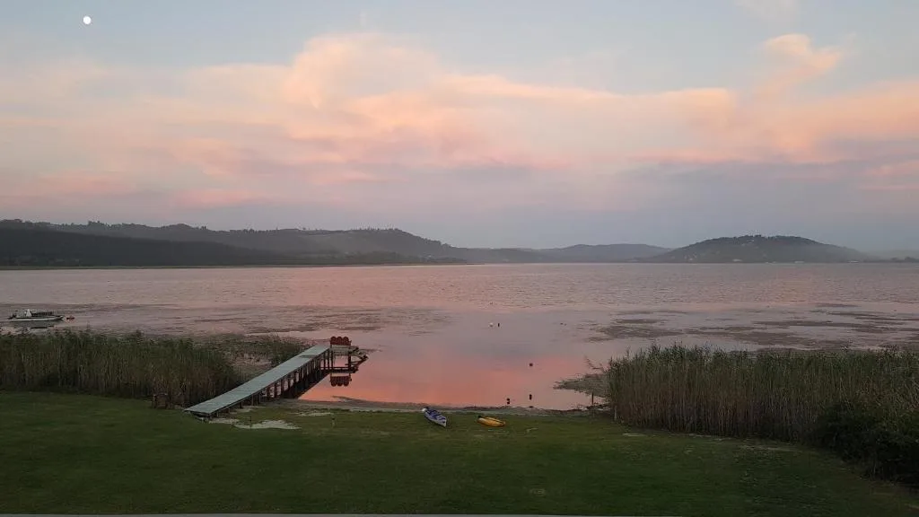 Serene lagoon sunset with mountains, dock, and reeds from property