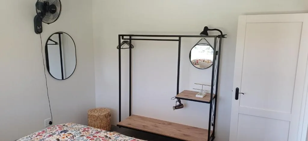 Modern bedroom with black metal four-poster bed frame and wooden platform