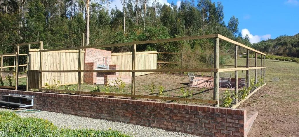 Fenced garden area with brick base and wooden frame structure