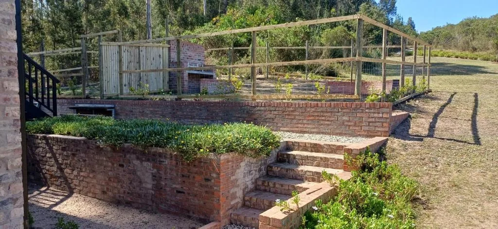 Brick garden enclosure with wooden deck and fenced vegetable area