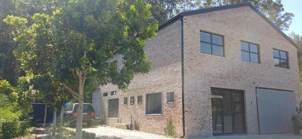 Brick residential building with mature trees and driveway entrance