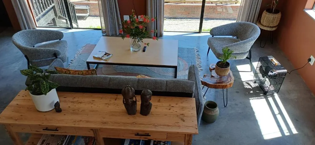 Modern lounge with gray armchairs, wooden table, and bright natural light