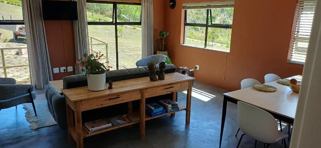 Open-plan lounge with wooden table, comfortable seating, and garden views