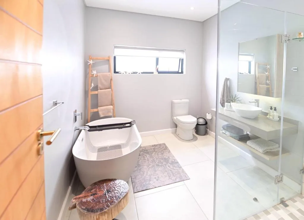 Modern bathroom with freestanding soaking tub and glass shower enclosure