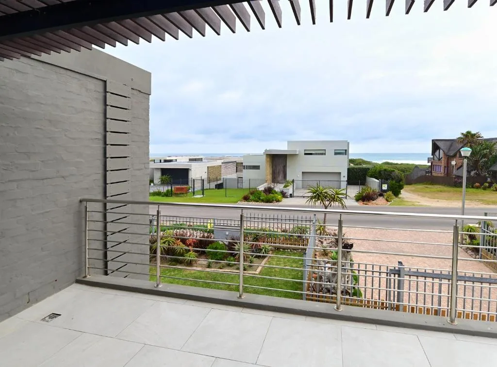 Modern patio with steel railing overlooking contemporary homes and ocean views