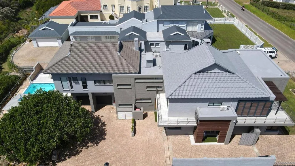 Aerial view of modern residential property with pool and manicured grounds