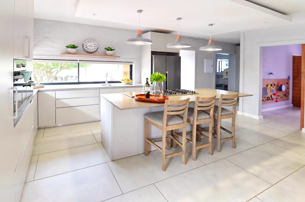 Modern white kitchen with island seating and stainless steel appliances