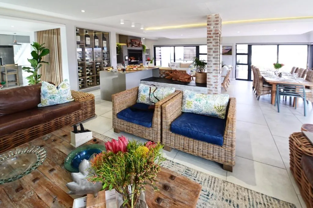 Open-plan living area with wicker seating, leather sofa, and ocean views