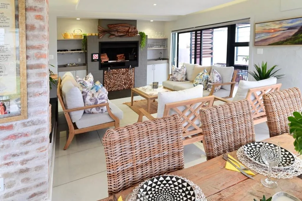 Modern open-plan lounge with fireplace, comfortable seating, and garden views