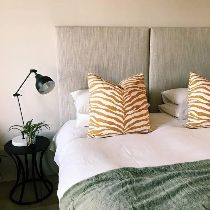 Modern bedroom with striped accent pillows and contemporary black reading lamp