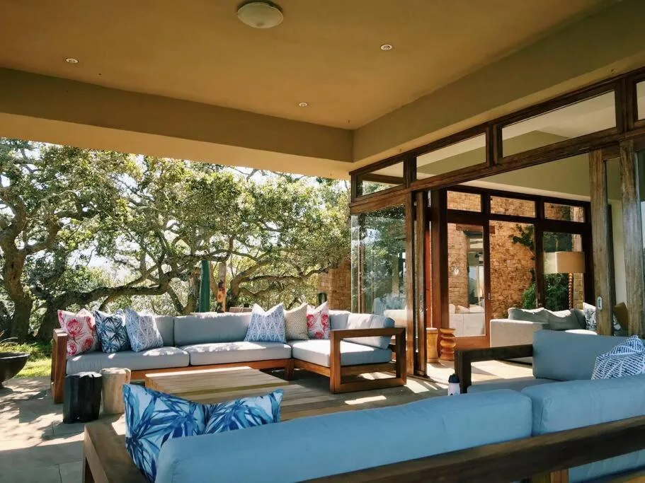 Spacious covered patio with seating area overlooking mature oak trees