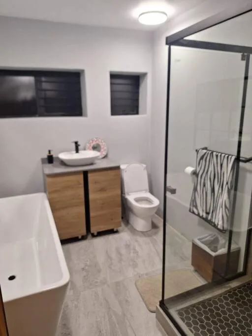 Modern bathroom with freestanding tub, wooden vanity, and walk-in shower