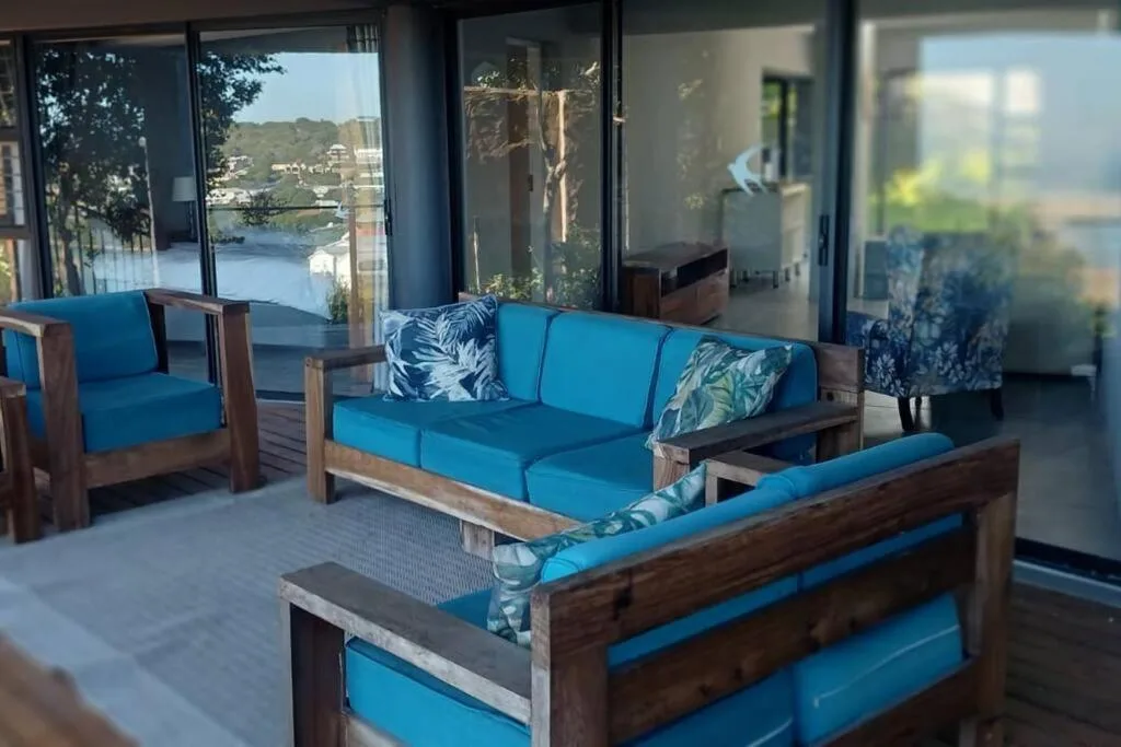 Bright blue outdoor furniture with water views through large sliding glass doors