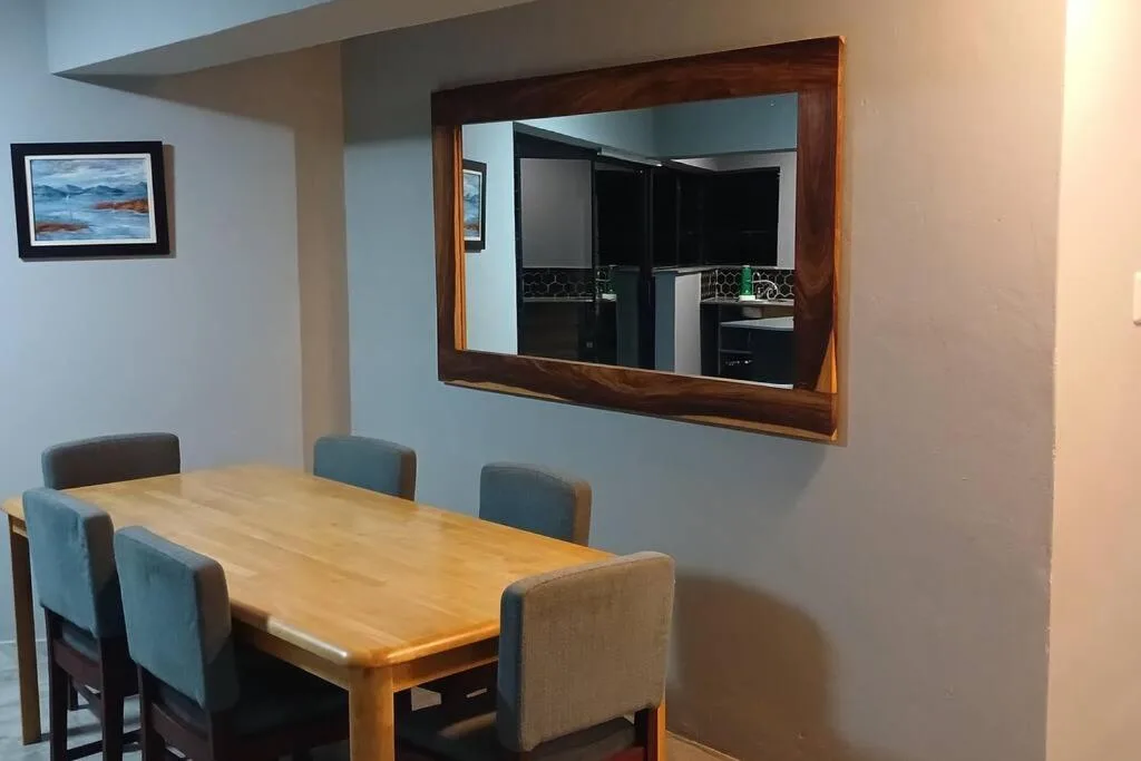Wooden dining table with upholstered chairs in modern room