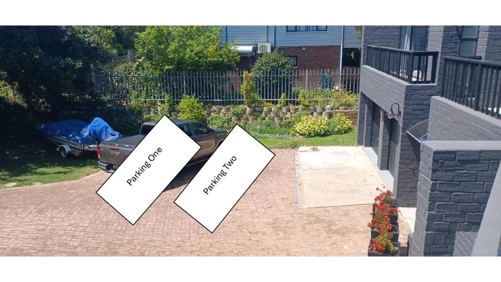 Brick driveway with parking spaces and garden views