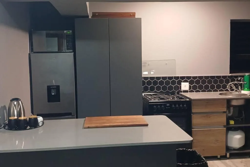Modern kitchen with stainless steel appliances and hexagonal backtile