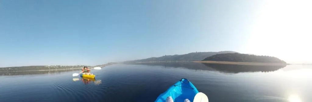 Serene lagoon view with islands, kayaks, and tree-lined shores