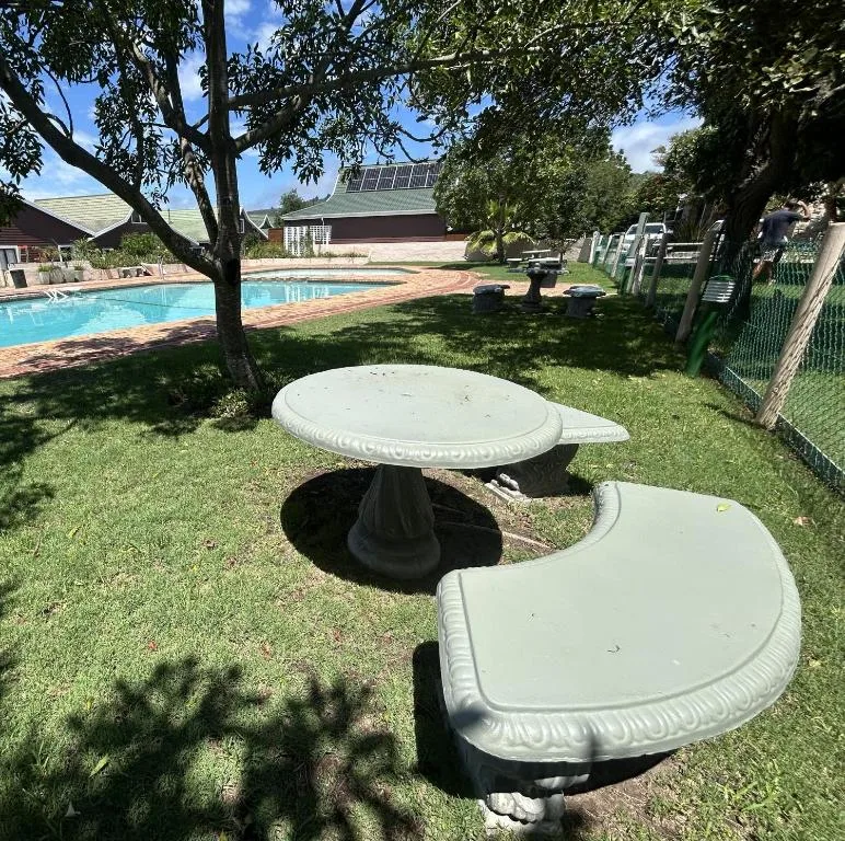 Garden seating area with mushroom tables overlooking swimming pool