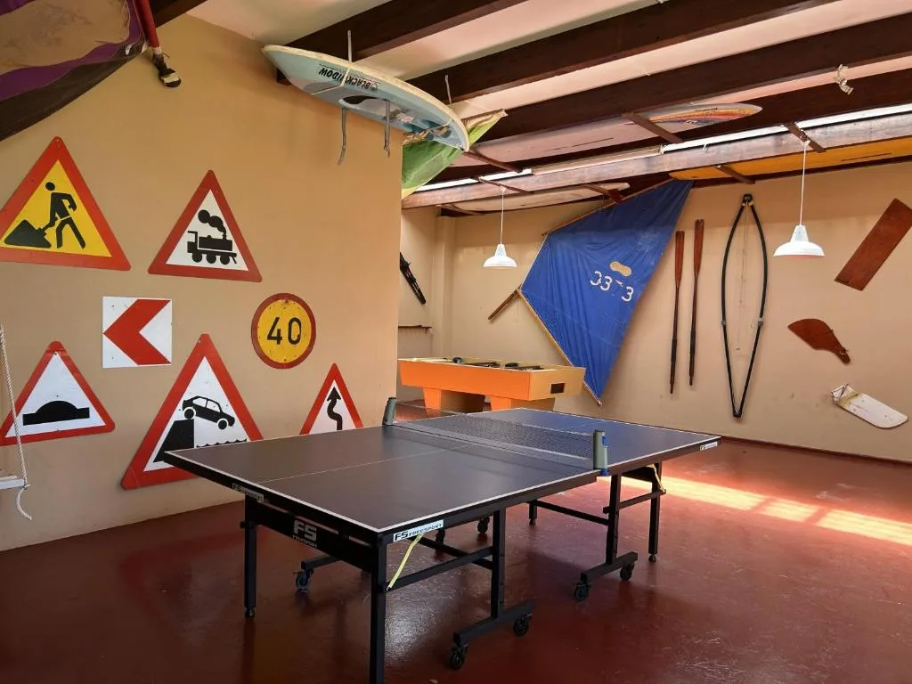 Games room with ping pong table, surfboards, and quirky road signs