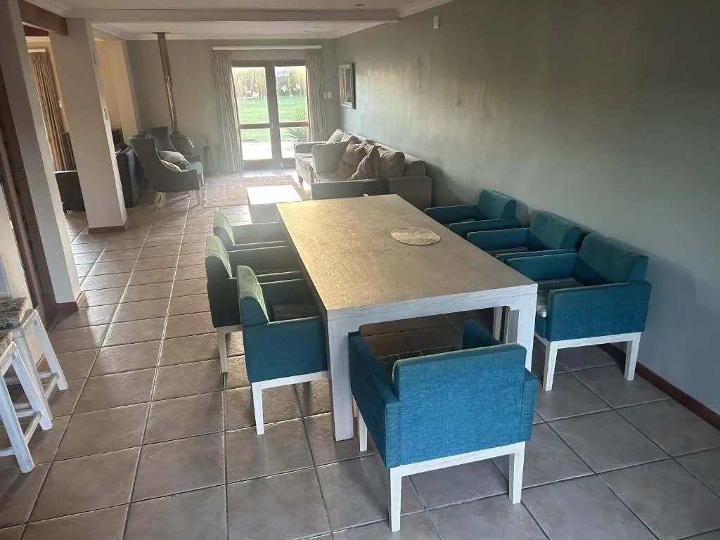 Spacious dining area with wooden table and blue upholstered chairs