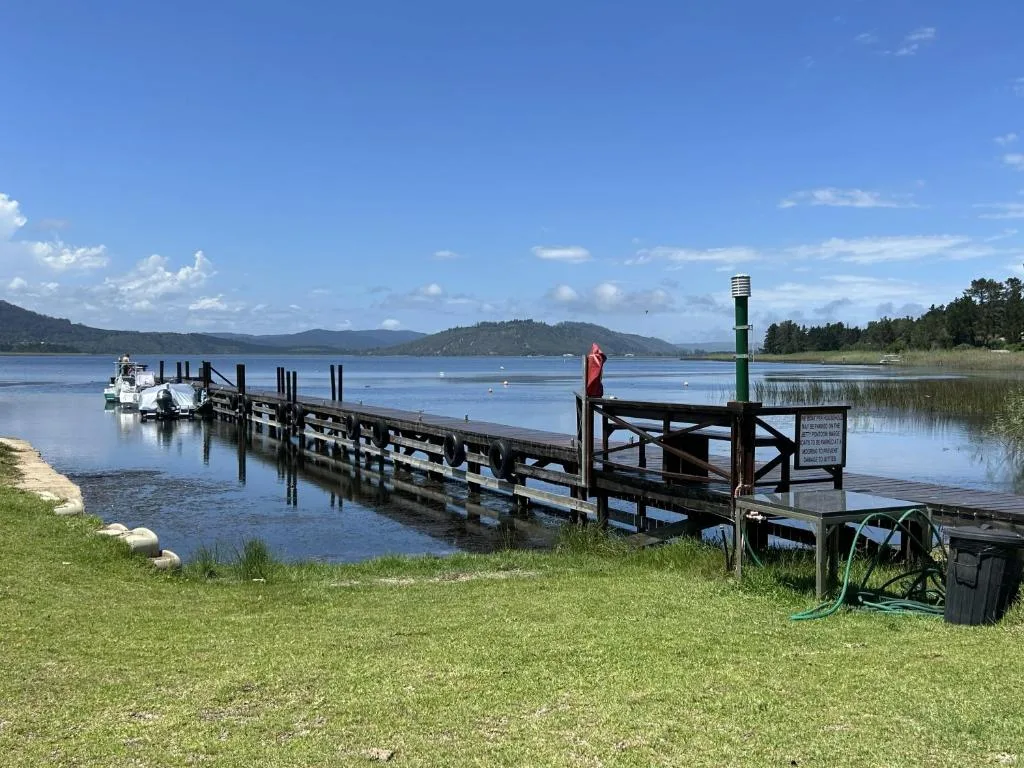 Scenic lagoon view with wooden dock, mountains, and pristine blue water