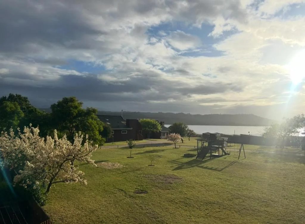 Scenic lagoon view from spacious garden with blooming trees and playground