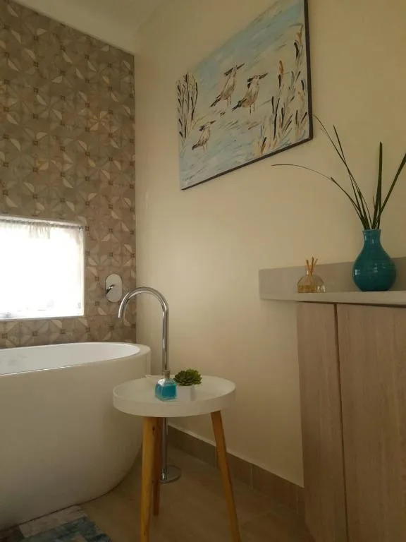 Modern bathroom with freestanding white bathtub and elegant fixtures