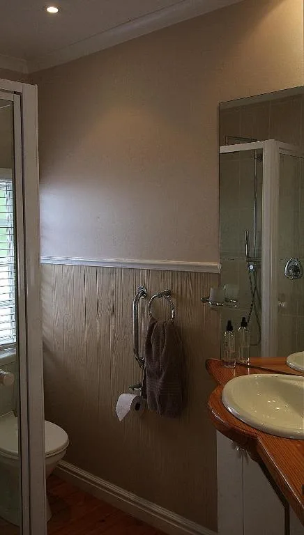 Spacious bathroom with shower enclosure, double vanity sink, and wooden accents