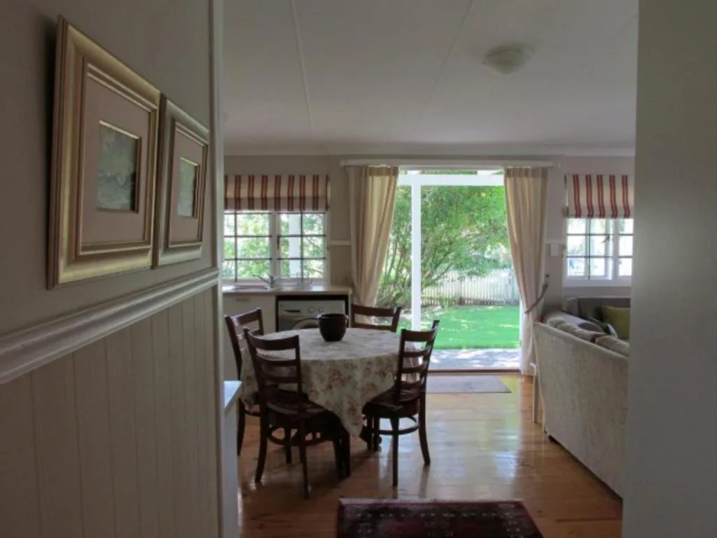 Bright dining room with round table, wooden chairs, and garden view doors