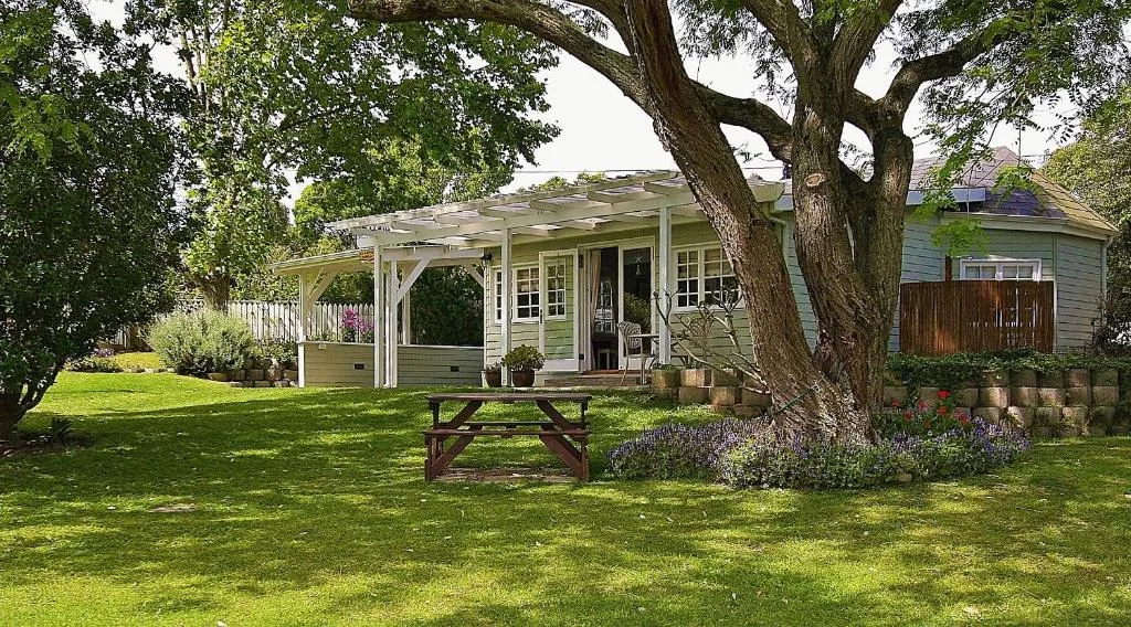 Charming cottage with covered deck and mature trees in garden