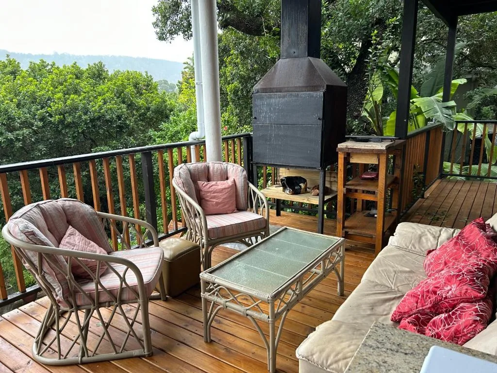 Wooden deck with comfortable seating, braai, and mountain views