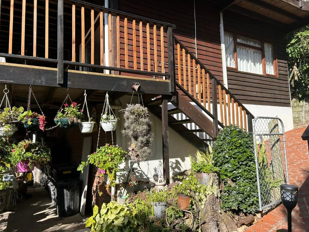 Modern apartment exterior with wooden railings and hanging flower baskets