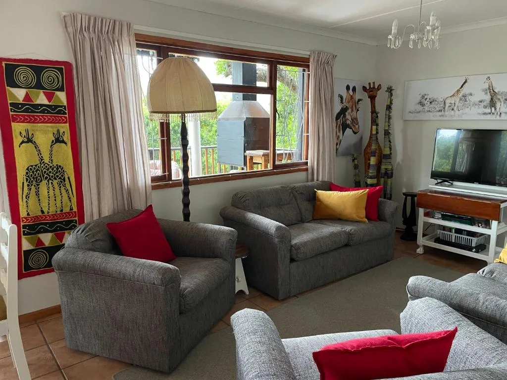 Spacious lounge with gray sofas, African artwork, and large windows