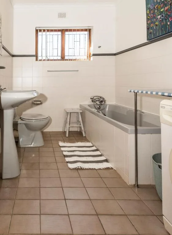Spacious bathroom with toilet, basin, bathtub and natural light