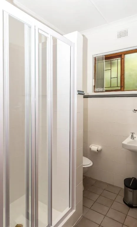 Clean bathroom with shower enclosure, toilet, and wall-mounted sink
