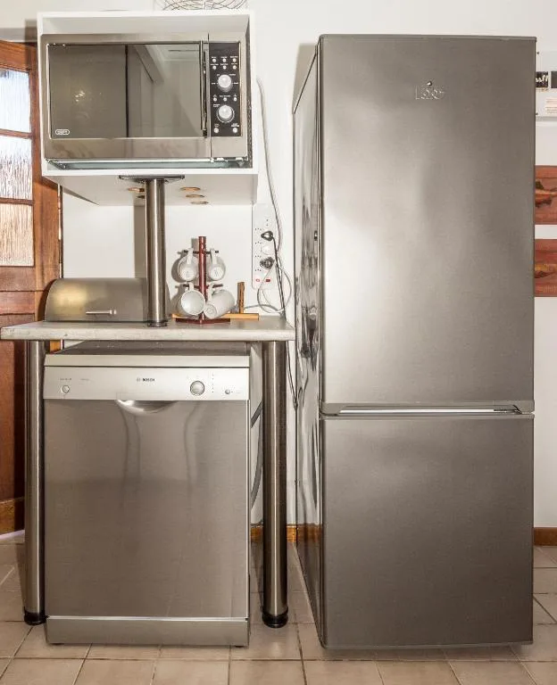 Compact kitchen with stainless steel appliances and microwave oven setup