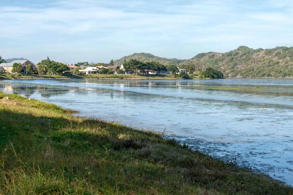 Scenic river vista with lush hills, tree-lined banks, and distant homesteads